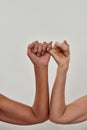 Close up shot of two female hands making pinky swear. Promise hand gesture isolated over light background Royalty Free Stock Photo