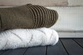 Close-up shot of two knitted from natural wool sweaters, on a black wooden table, selective focus