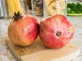 Close up shot of two red pomegranates on a wooden board