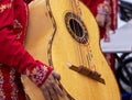 Close up shot of unrecognizable mariachi woman, holds a mariachi GuitarrÃÂ³n Mexicano (big