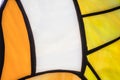 Close-up shot of varicoloured stained glass window backlit by the sun. Part of a yellow-orange stained glass window with large Royalty Free Stock Photo