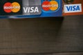 Close up shot of VISA and MasterCard bank cards with brown wooden background