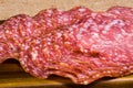 Close up shot of well folded salami on a wooden board and canvas