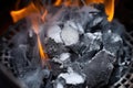 close-up shot of white hot charcoals inside a metal chimney starter