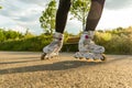 Close-up shot of white Inline skates on the path. Woman`s legs with roller blades at sunny day. Royalty Free Stock Photo