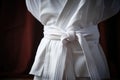 a close-up shot of a white karate belt tied around a gi