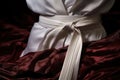 a close-up shot of a white karate belt tied around a gi