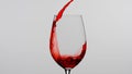 Close up shot of wine glass isolated on white background in studio. Red wine pouring into a beautiful goblet from the Royalty Free Stock Photo