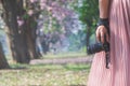 Close-up shot of woman hand holding  camera. Young hipster photographer preparing shooting camera in outdoor nature landscape Royalty Free Stock Photo