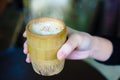 close-up shot of a woman hand holding a coffee cup made of a bamboo. Royalty Free Stock Photo