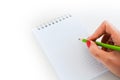 Close-up shot of woman hand holding a pan about to write on a blank notebook