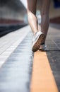 Close up shot woman legs wearing canvas shoes walking on yellow