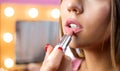 Close up shot of a woman putting lipstick on her lips Royalty Free Stock Photo