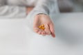 Close-up shot of a woman`s hand holding a few yellow pills Royalty Free Stock Photo
