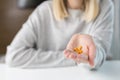 Close-up shot of a woman`s hand holding a few yellow pills Royalty Free Stock Photo