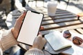 A close up shot of a woman& x27;s hand holding an phone with a blank screen sitting at an outdoor cafe table, notebook on Royalty Free Stock Photo