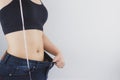 Close up shot of woman with slim body measuring her waistline and torso. Healthy nutrition, diet and weight losing concept Royalty Free Stock Photo