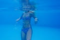 Close-up shot of a woman swimming underwater in the pool. Royalty Free Stock Photo