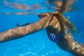 Close-up shot of a woman swimming underwater in the pool. Royalty Free Stock Photo