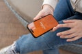 A close-up shot of a woman using the Payoneer application on her iPhone while sitting outdoor