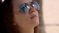 Close up shot of a woman wearing sunglasses at the beach under palm trees Royalty Free Stock Photo