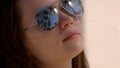 Close up shot of a woman wearing sunglasses at the beach under palm trees Royalty Free Stock Photo