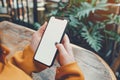 A close up shot of a woman& x27;s hand holding an phone with a blank screen sitting at an outdoor cafe table, notebook on Royalty Free Stock Photo