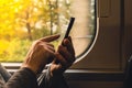 Close-up shot of woman& x27;s hands tapping on mobile phone screen. Girl in plaid shirt using modern smart phone Royalty Free Stock Photo