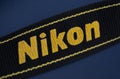 Yellow Nikon DLSR camera logo on neck strap Royalty Free Stock Photo