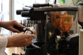 Close-up shot of young beautiful baretta making coffee with modern coffee machine. Royalty Free Stock Photo