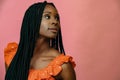 close up shot of young black woman looking away on pink background