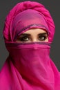 Close-up shot of a young charming woman wearing the pink hijab decorated with sequins. Arabic style. Royalty Free Stock Photo