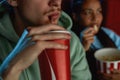 Close up shot of young guy drinking soda while watching movie at the cinema Royalty Free Stock Photo