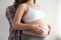 Close up shot of young man hugging his pregnant wife from behind over isolated white background. Prenatal period concept. Young Royalty Free Stock Photo