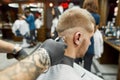 Close up shot of a young man visiting barbershop and getting new trendy haircut. Barber working with hair clipper, back Royalty Free Stock Photo