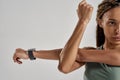 Close up shot of a young mixed race fitness woman in sportswea stretching her arms before workout while standing