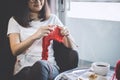 Close up shot of young woman hands knitting a red scarf handicraft in the living room on terrace at home Royalty Free Stock Photo