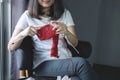 Close up shot of young woman hands knitting a red scarf handicraft in the living room on terrace at home Royalty Free Stock Photo