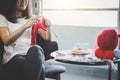 Close up shot of young woman hands knitting a red scarf handicraft in the living room on terrace at home Royalty Free Stock Photo