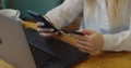 Close up shot of young woman using credit card and laptop for online shopping in cafe.