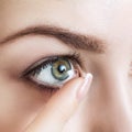 Close-up shot of young woman wearing contact lens. Royalty Free Stock Photo