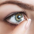 Close-up shot of young woman wearing contact lens. Royalty Free Stock Photo