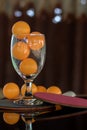 Close-up shot of orange ping pong in clear glass. Royalty Free Stock Photo