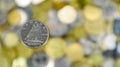 A close-up shows one 10-cent coin. This is money. Blurred money background. Dime, the smallest 0.10 Canadian dollar coin. The