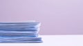 Stack of papers on white surface with purple background Royalty Free Stock Photo