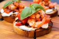 close-up of shrimp resting on a toasted bruschetta slice