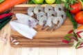 Close up of shrimp, squid, and fresh vegetables on wooden block for prepare cooking