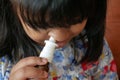 close up of sick child using nasal medicine spray