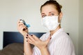 Close-up of sick woman in a medical mask with bronchodilator in her hand . Coronavirus epidemic