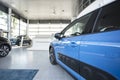 Close-up of a side door of a blue car on a spacious display in a